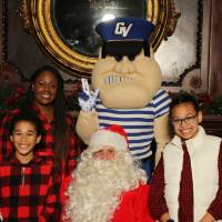 Santa and Louie posing with alumni family of three